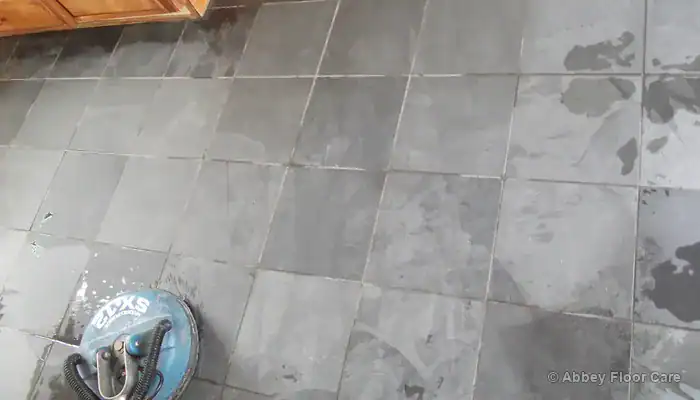 Damaged slate floor with flaking edges and worn high spots